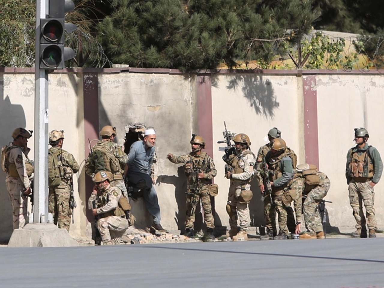 Afganskí vojaci zachraňujú muža zo sídla  afganskej televíznej stanice Šamšád.
