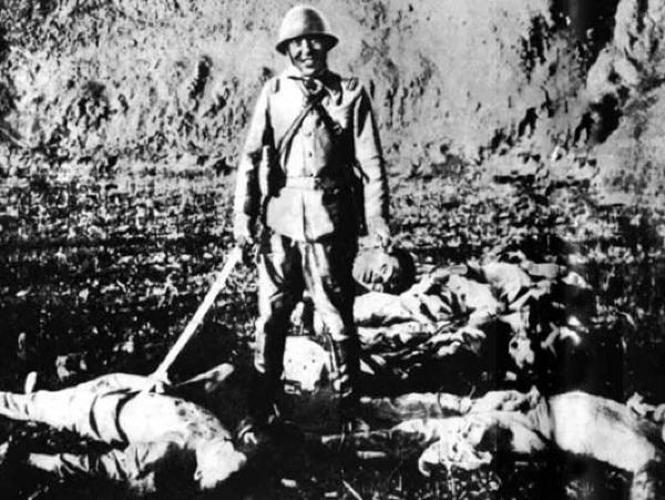 Japonský vojak pózuje s mŕtvolami zabitých Číňanov