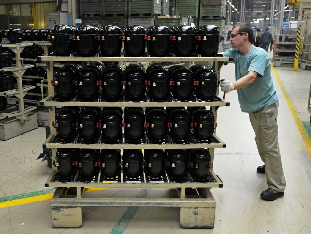 Robotník presúva kompresory v závode na výrobu kompresorov Embraco Slovakia