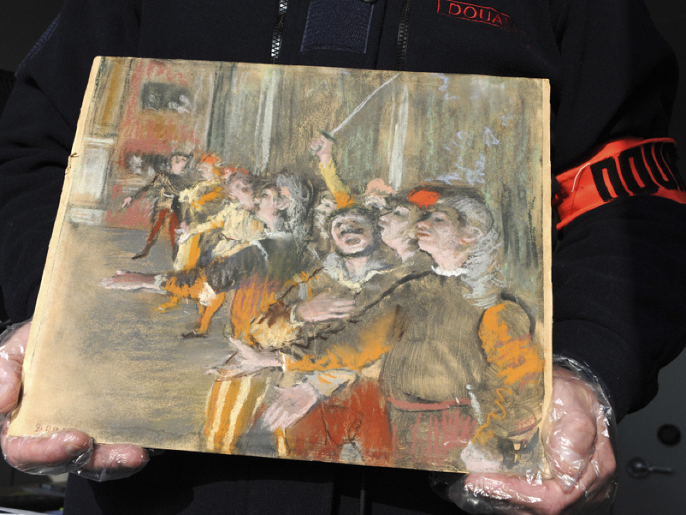 Na snímke francúzsky colník drží  vyše osem rokov nezvestný obraz od impresionistického maliara Edgara Degasa, ktorý objavili v batožinovom priestore autobusu.