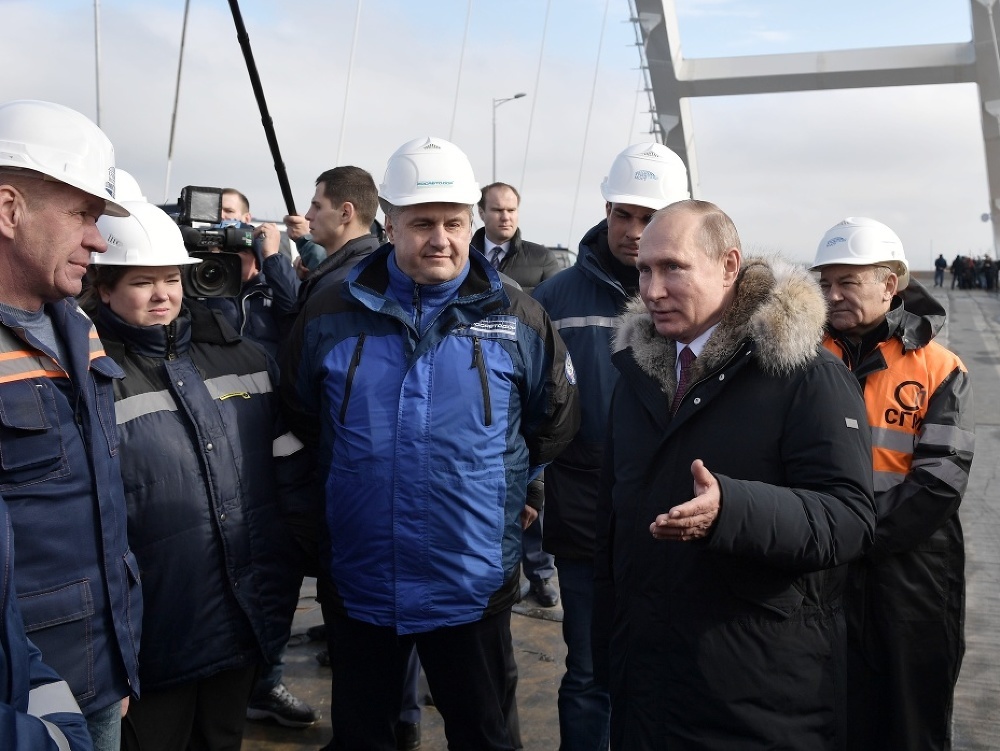 Na snímke ruský prezident Vladimir Putin (v strede) počas rozhovoru so staviteľmi a robotníkmi