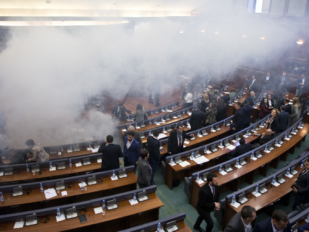 Kosovskí poslanci odchádzajú po tom, čo opoziční poslanci hodili kanistre so slzotvorným plynom počas zasadnutia parlamentu 21. marca 2018 v Prištine.