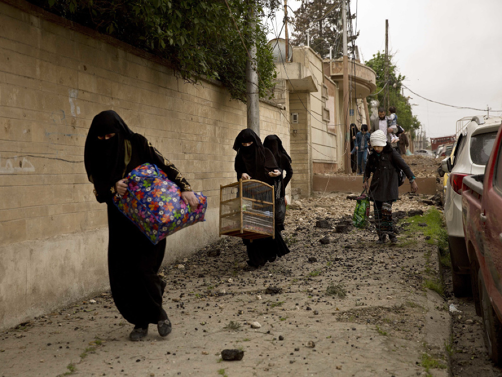 Iracké ženy utekajú na ulici počas ťažkých bojov v štvrti Jarmúk v západnej časti irackého mesta Mósul