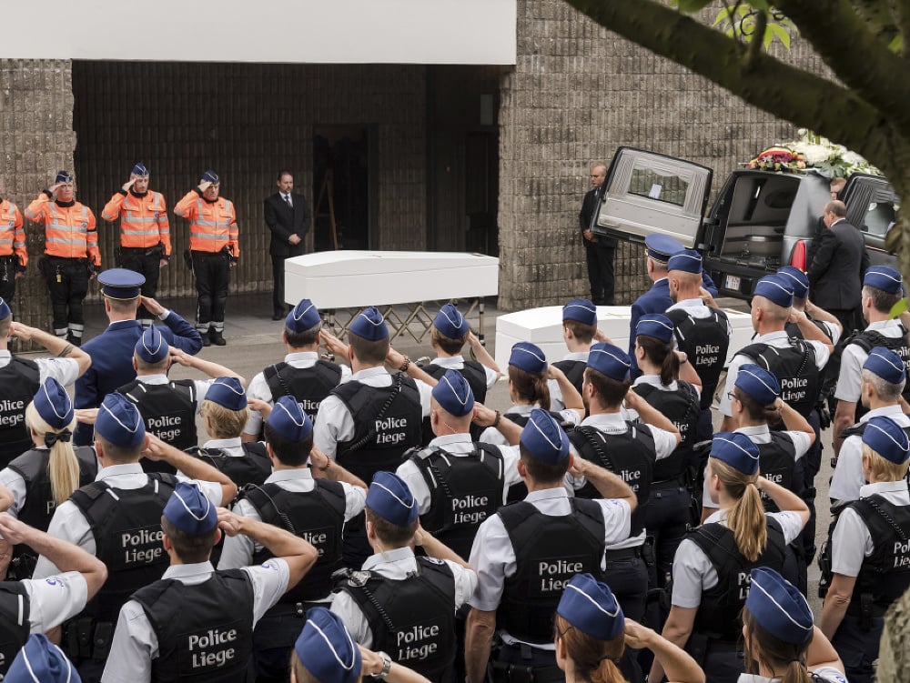 Policajti salutujú pri rakvách s telesnými pozostatkami dvoch policajtiek Sorayi Belkacemiovej a Lucile Garciovej počas ich pohrebu v belgickom meste Liege