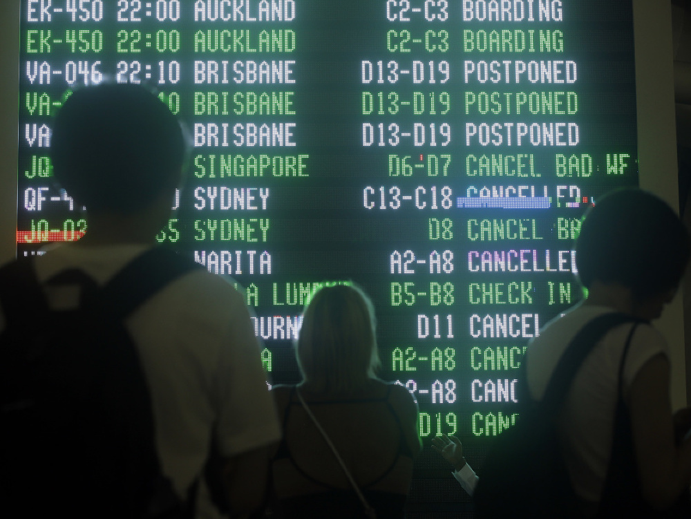 Ľudia na letisku sledujú informácie o zrušených letoch na Bali