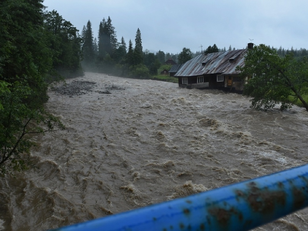 Rozvodnený potok Javorinka, ktorý berie so sebou starší dom v Podspádoch vo Vysokých Tatrách.