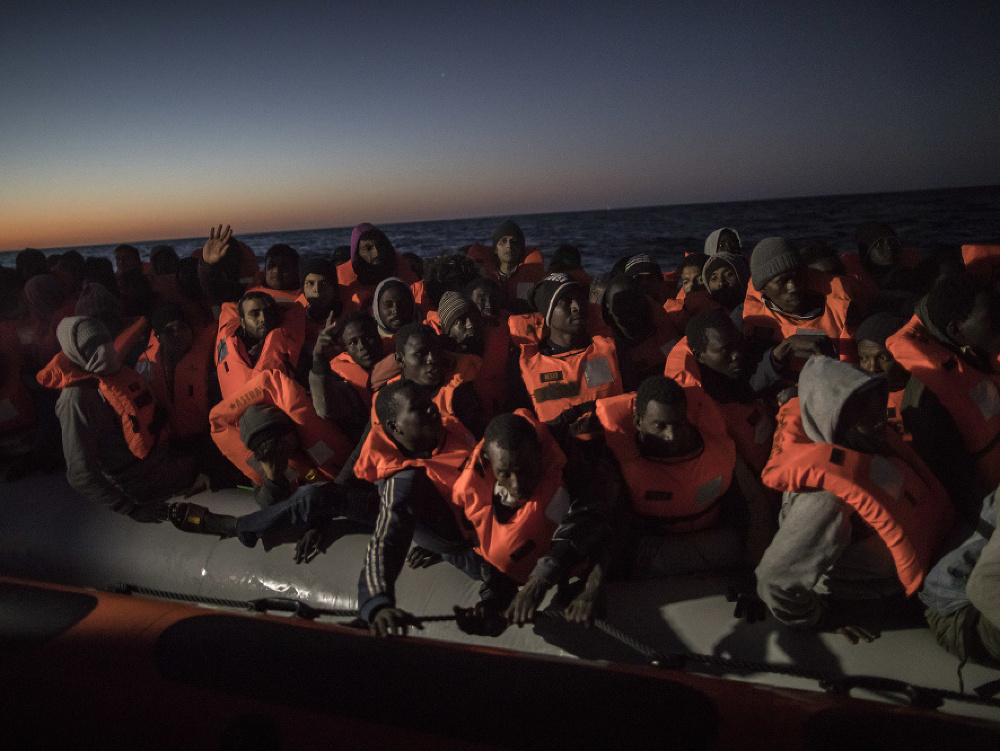 Na archívnej snímke migranti a utečenci zo subsaharskej Afriky rôznych národností opúšťajú na člne líbyjské pobrežie a plavia sa do Európy.