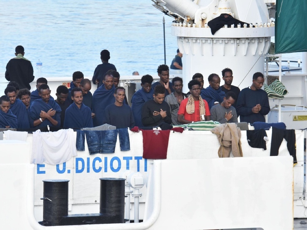 Migranti sa modlia na palube námorného plavidla Diciotti talianskej pobrežnej stráže