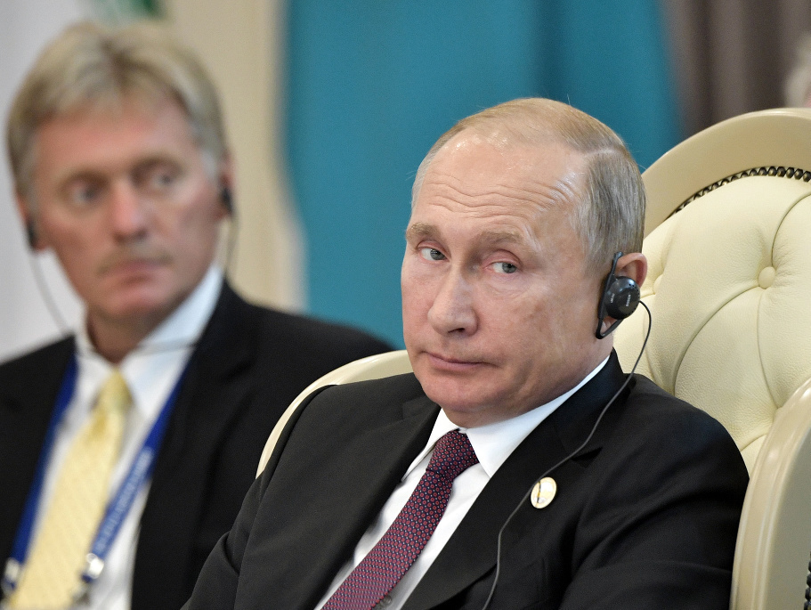 Vladimír Putin, v pozadí Dmitrij Peskov