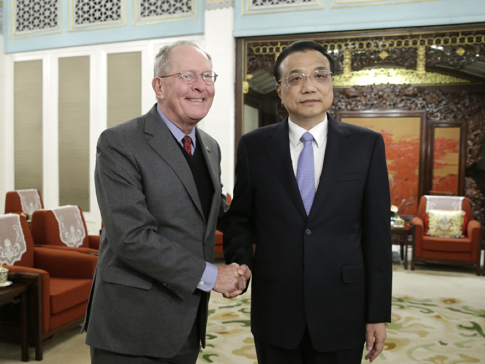 Čínsky premiér Li Keqiang (vpravo) si podáva ruku s americkým senátorom Lamarom Alexandrom.