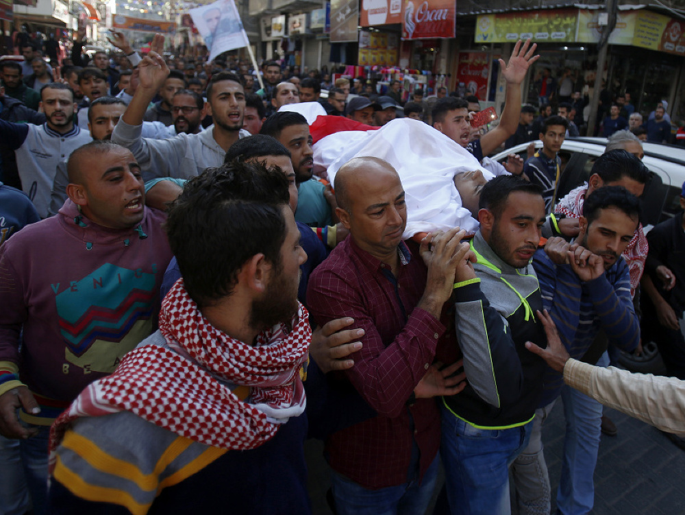Ľudia nesú zosnulé telo Palestínčana, ktorý zahynul pri streľbe. 