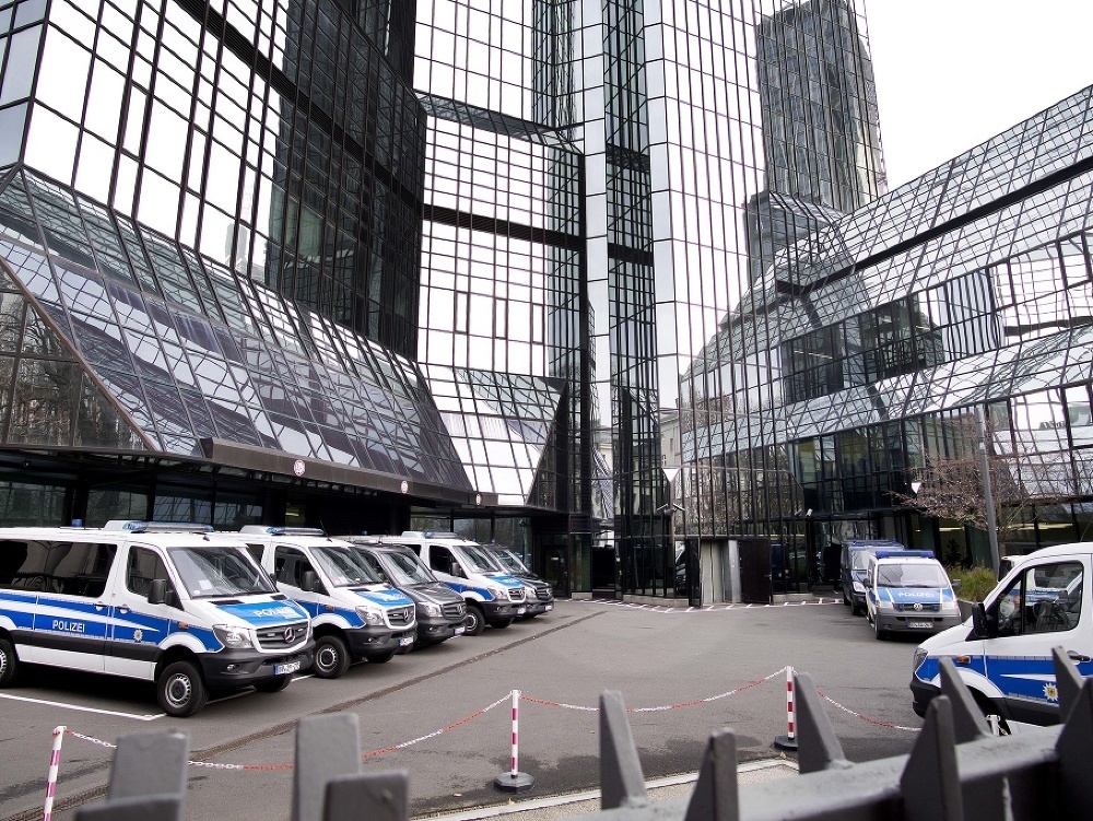 Policajné autá parkujú pri centrále spoločnosti Deutsche Bank.