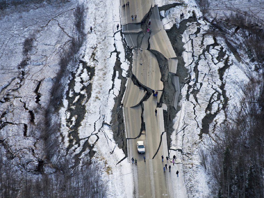 Na archívnej leteckej snímke z 30. novembra 2018 je v dôsledku zemetrasenia popraskaná a zvlnená cesta s názvom Vine Road na kopci pri meste Wasilla
