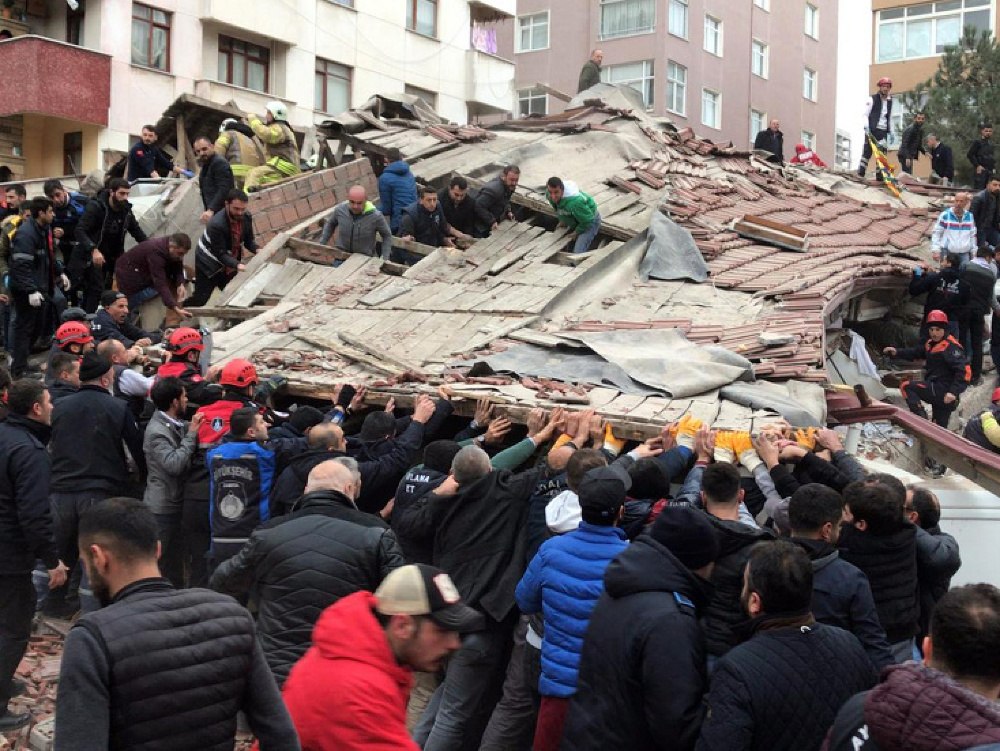 Záchranári a ľudia prehľadávajú trosky po zrútení obytnej budovy v Istanbule