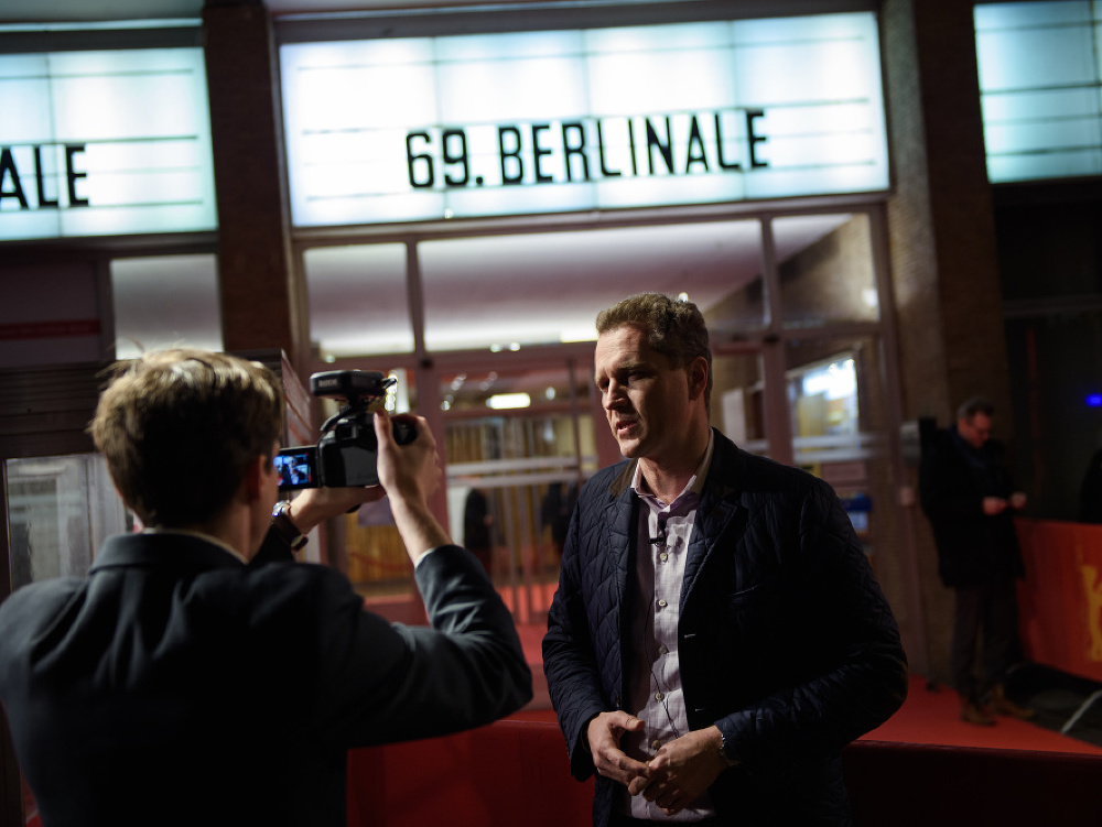 Poslanec krajne pravicovej strany Alternatíva pre Nemecko (AfD) Petr Bystron stojí pred kinom počas premiéry filmu Who do you think I am