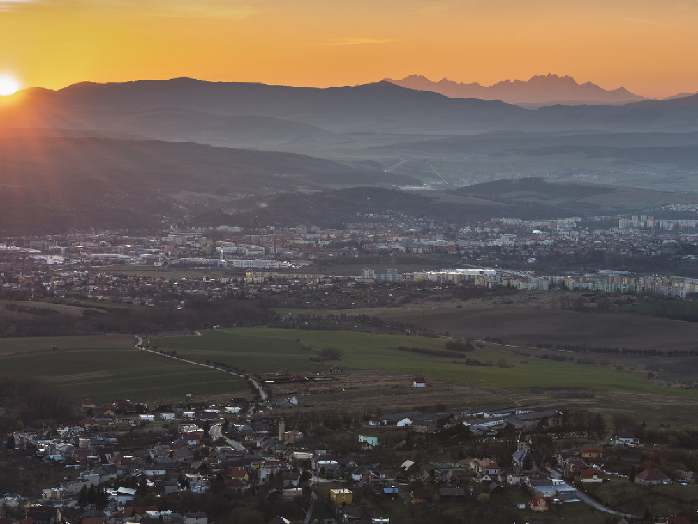 Na snímke v popredí obec Ruská Nová Ves, uprostred Prešov a vpravo hore Vysoké Tatry v posledných lúčoch slnka.
