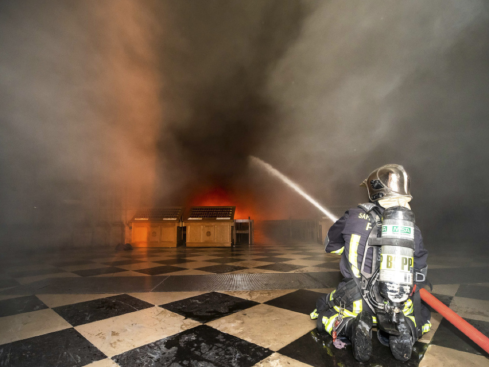 Hasič uhasujúci požiar v katedrále Notre-Dame