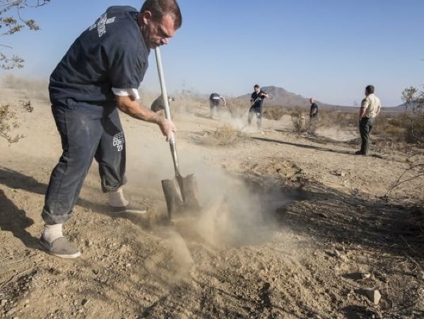 Robotník zakopáva plytký hrob, kde boli pozostatky