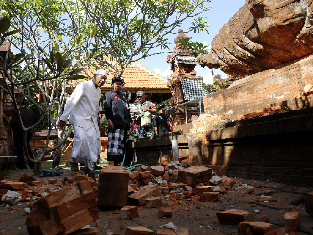 Muž kontroluje poškodený chrám na indonézskom ostrove Bali 