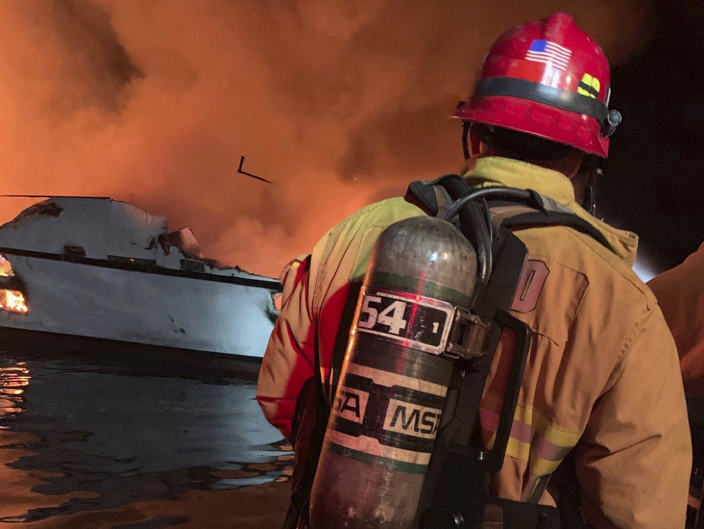 Hasič zasahuje počas požiara, ktorý vypukol na lodi s desiatkami pasažierov 