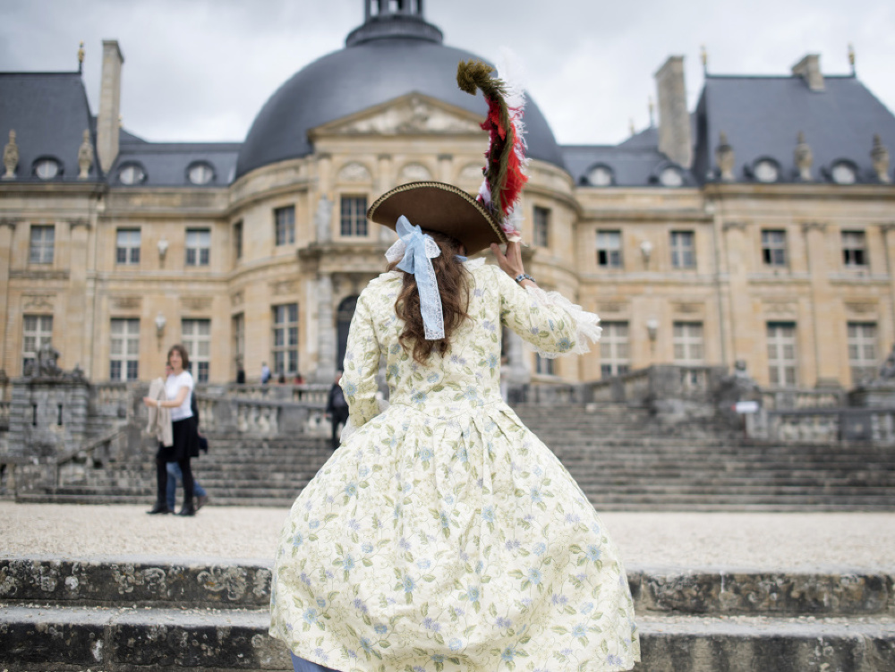 Na archívnej snímke žena oblečená v kostýme počas návštevy zámku Vaux-le-Vicomte pri Paríži. 