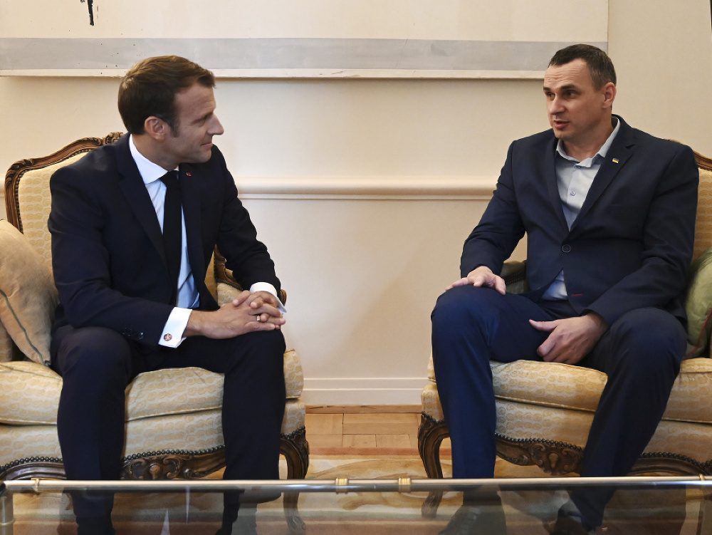 Francúzsky prezident Emmanuel Macron sa rozpráva s bývalým väzňom a ukrajinským režisérom Olehom Sencovom