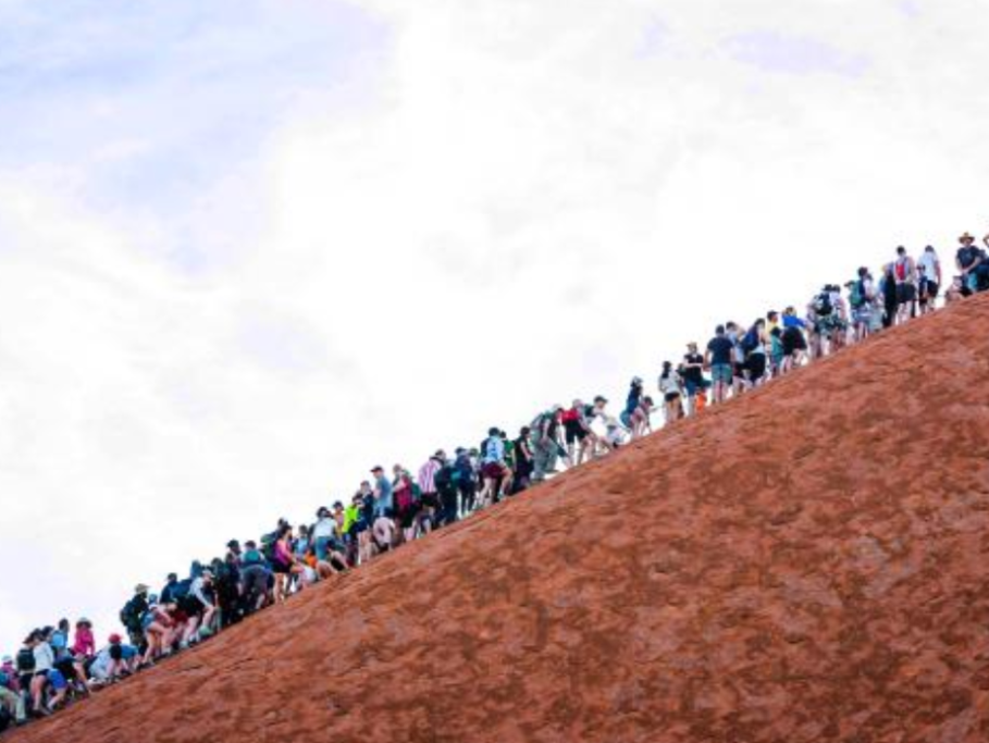 Turisti v húfoch lezú na posvätnú horu