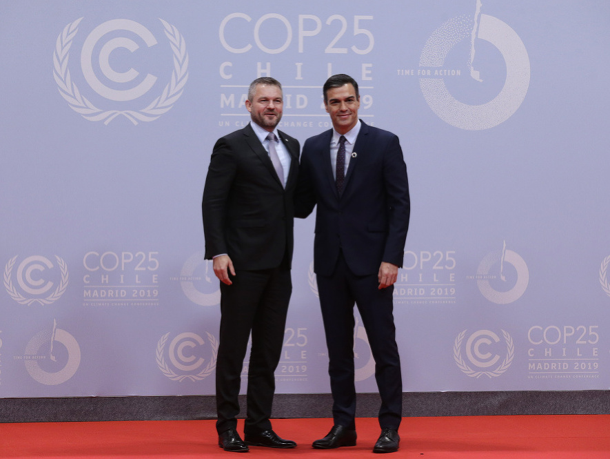 Španielsky premiér Pedro Sánchez (vpravo) a slovenský premiér Peter Pellegrini sa zdravia počas klimatického summitu v Madride 