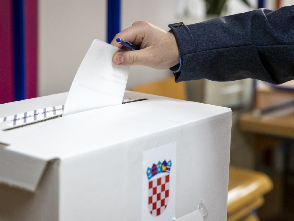 Chorvátsky volič hádže do urny svoj hlas počas hlasovania v prezidentských voľbách vo volebnej miestnosti v Záhrebe
