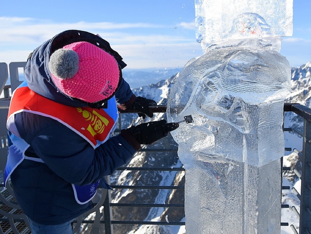 Na snímke účastník medzinárodných majstrovstiev v stavaní ľadových sôch Tatry Ice Master z Mongolska vyrezáva detaily sochy symbolizujúcej klimatické zmeny na Lomnickom štíte vo Vysokých Tatrách