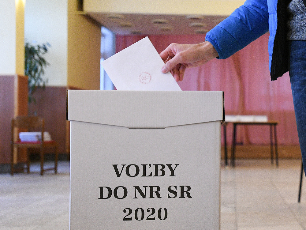 Volič vhadzuje svoj hlas do volebnej urny