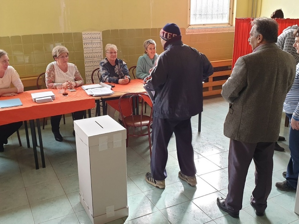 Na snímke voliči a členovia okrskovej volebnej komisie vo volebnej miestnosti vo voľbách do Národnej rady Slovenskej republiky na rómskom sídlisku Dúžavská cesta na okraji Rimavskej Soboty