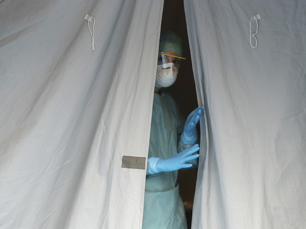 Zdravotníčka sa pozerá z jedného zo stanov pred nemocnicou v talianskom meste Brescia