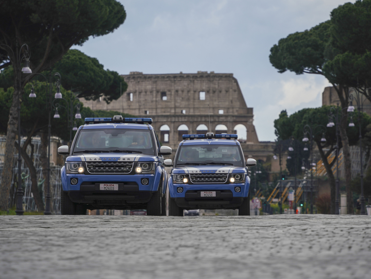 Policajné autá hliadkujú na ulici pred Koloseom v Ríme.