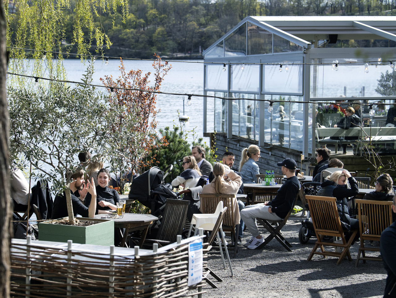 Ľudia pijú a jedia na terase reštaurácie v Štokholme počas koronavírusovej pandémie.