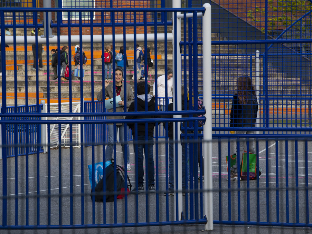 Učiteľ základnej školy v Holandsku čaká na svojich žiakov pred budovou školy