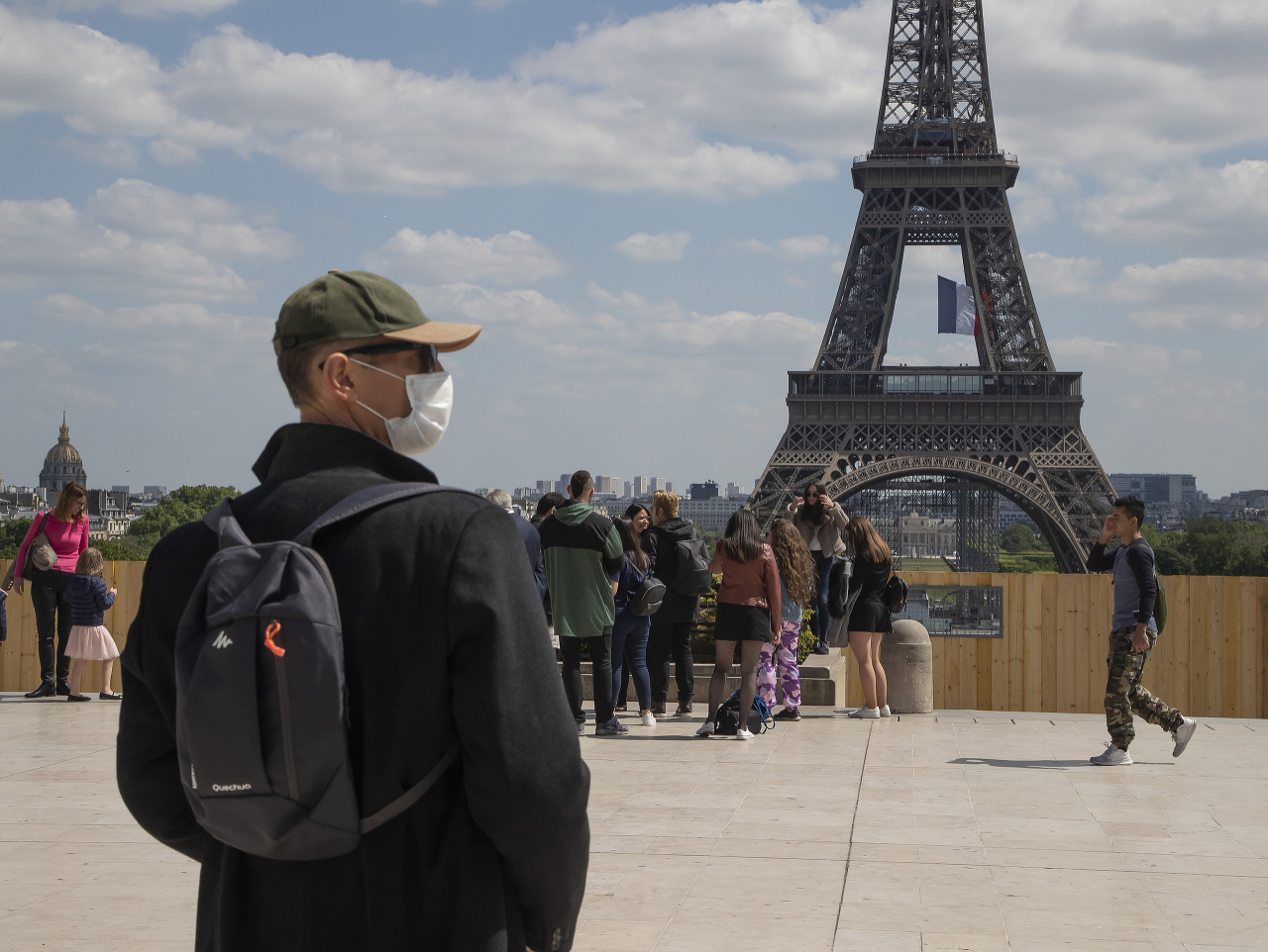 Muž v rúšku pred Eiffelovou vežou