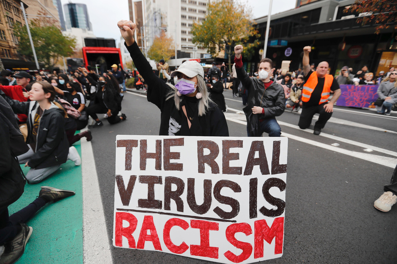 Demonštranti držia transparent počas protestného pochodu v centrálnom Aucklande na Novom Zélande