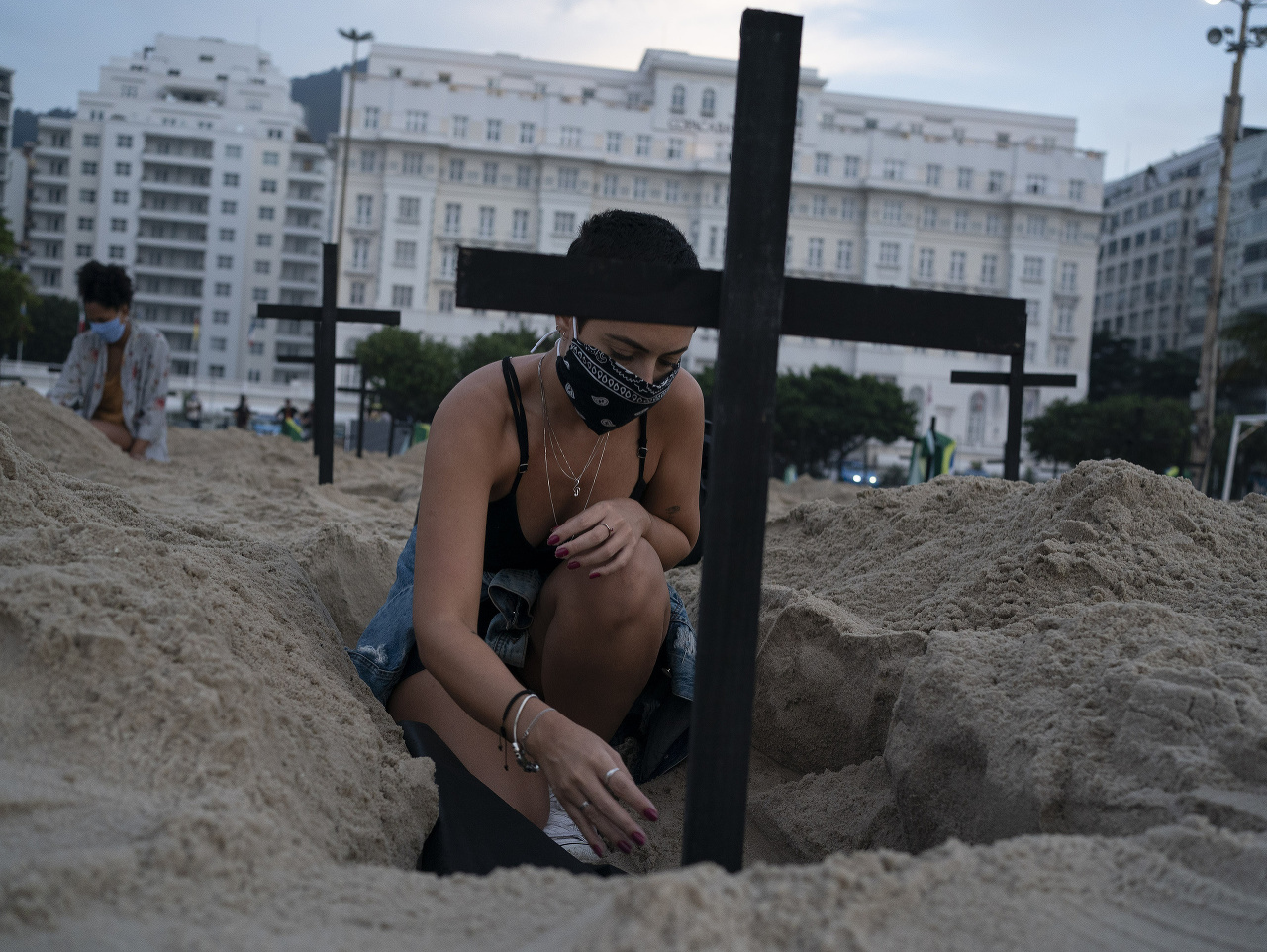 Aktivisti dávajú kríže do vykopaných hrobov na slávnej pláži Copababana v brazílskom meste Rio de Janeiro. Takýmto spôsobom vyjadrili úctu obetiam infekčného ochorenia COVID-19. 