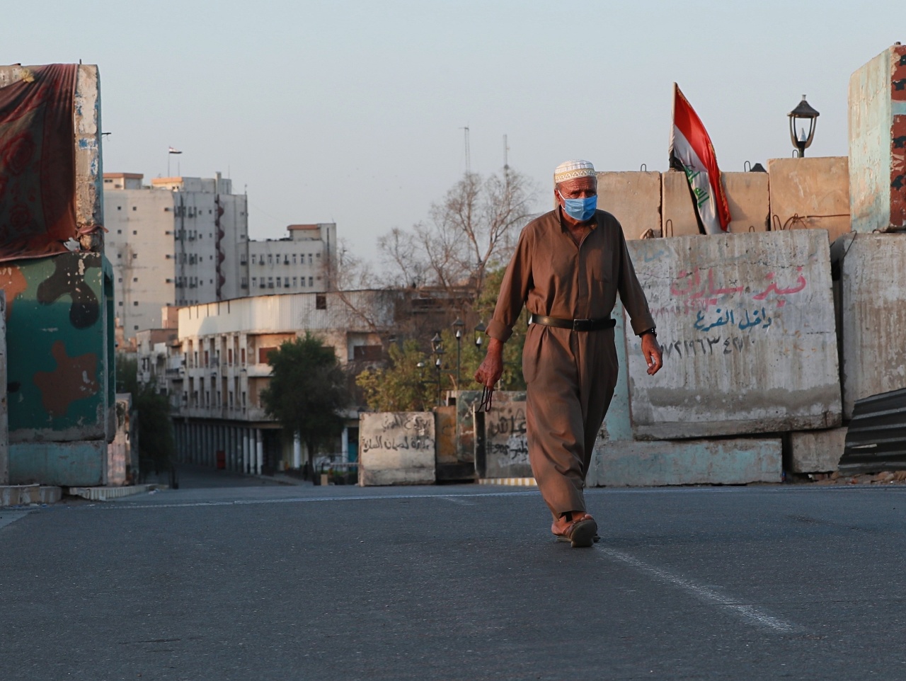 Iračan kráča po takmer prázdnej ulici v centrálnom Bagdade 