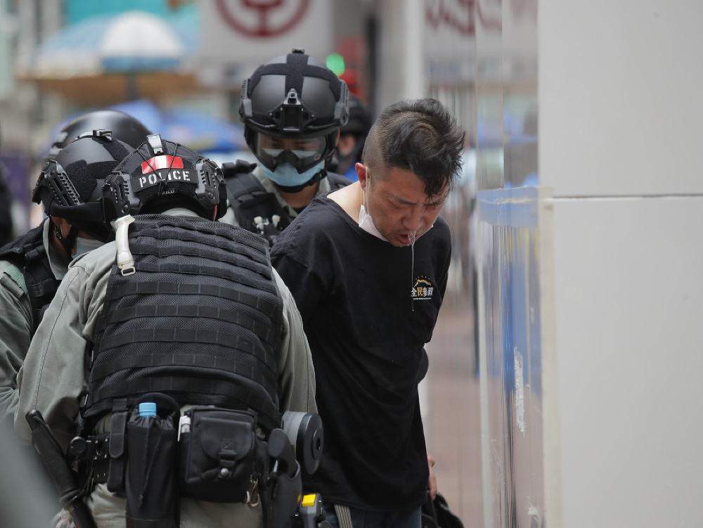 Policajti zatkli demonštranta, ktorého tvár zasiahol paprikový sprej pred slávnostným zhromaždením pri príležitosti 23. výročia prechodu Hongkongu pod čínsku správu v Hongkongu 