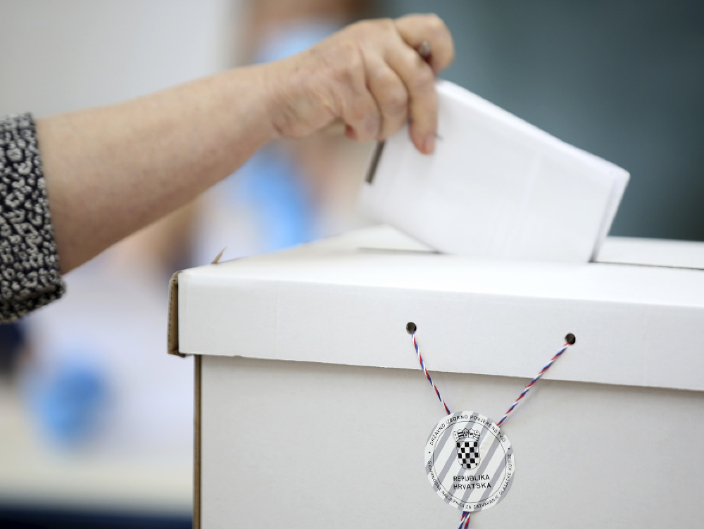 Volička vhadzuje hlas do volebnej urny v Záhrebe počas parlamentných volieb v Chorvátsku.