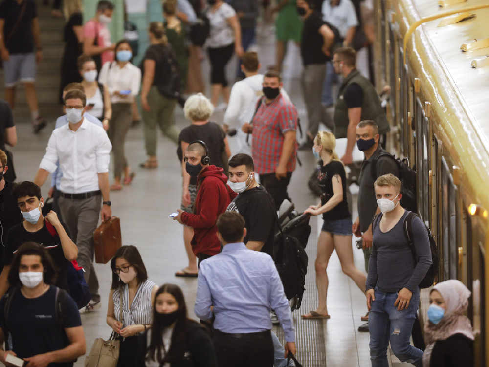 Ľudia s ochrannými rúškami na zabránenie šíreniu nového koronavírusu odchádzajú z vlakového nástupišťa na stanici Alexanderplatz v Berlíne.