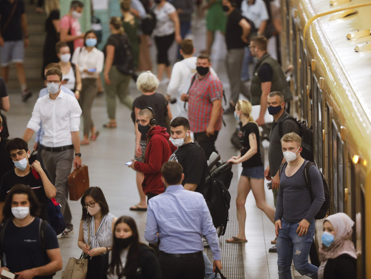 Ľudia s ochrannými rúškami na zabránenie šíreniu nového koronavírusu odchádzajú z vlakového nástupišťa na stanici Alexanderplatz v Berlíne.