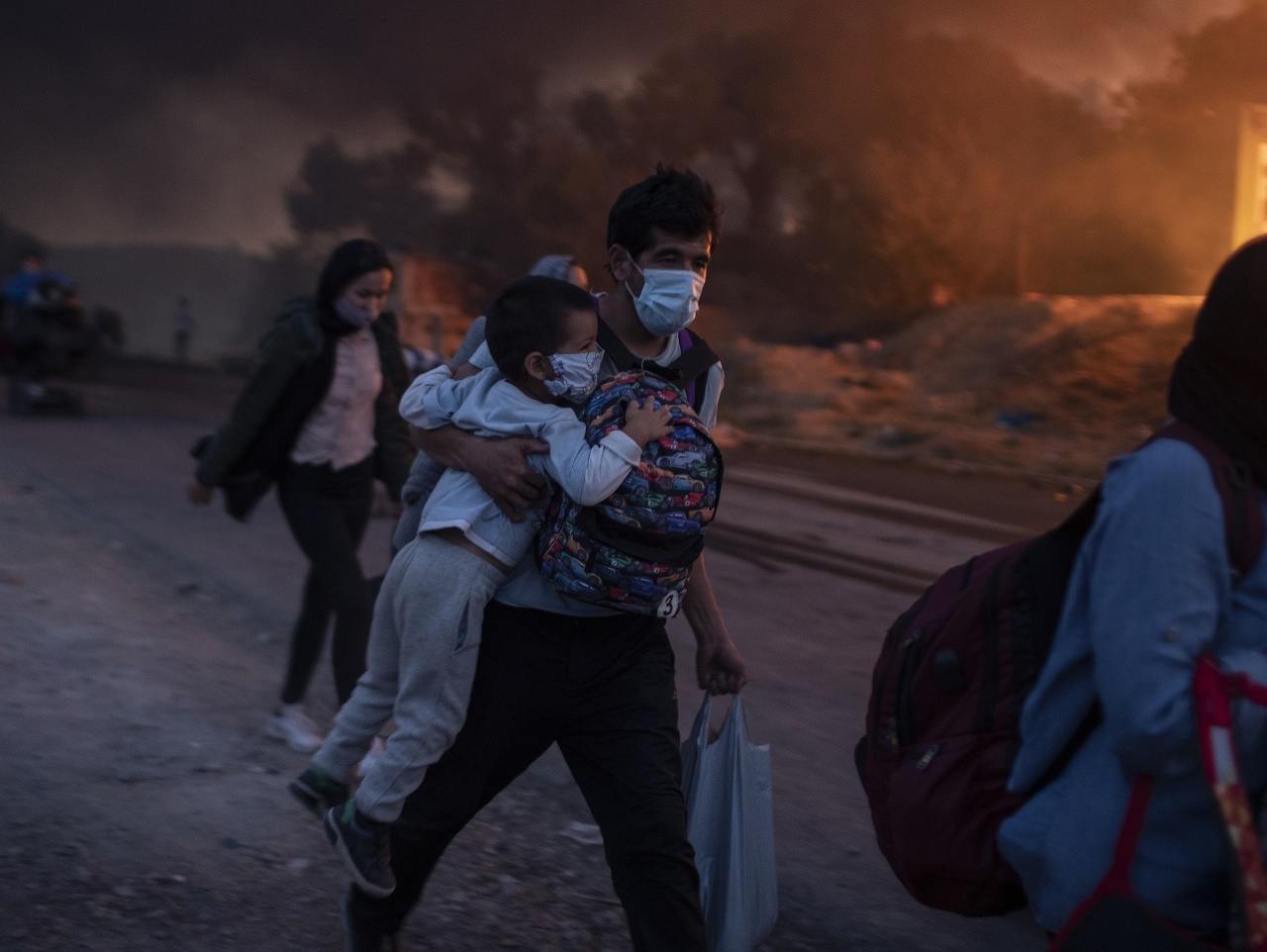 Na snímke migranti utekajú z tábora Moria po druhom požiari na gréckom ostrove Lesbos. 