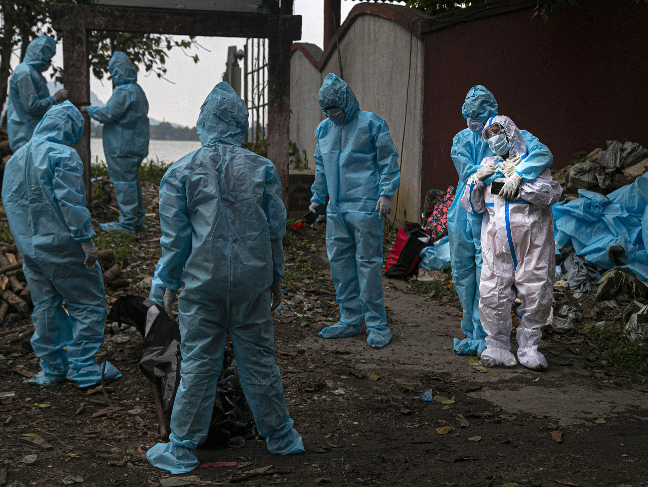 Žena v bielom ochrannom oblečení reaguje po tom, čo videla telo svojho manžela, obete koronavírusu v indickom meste Gauháti.