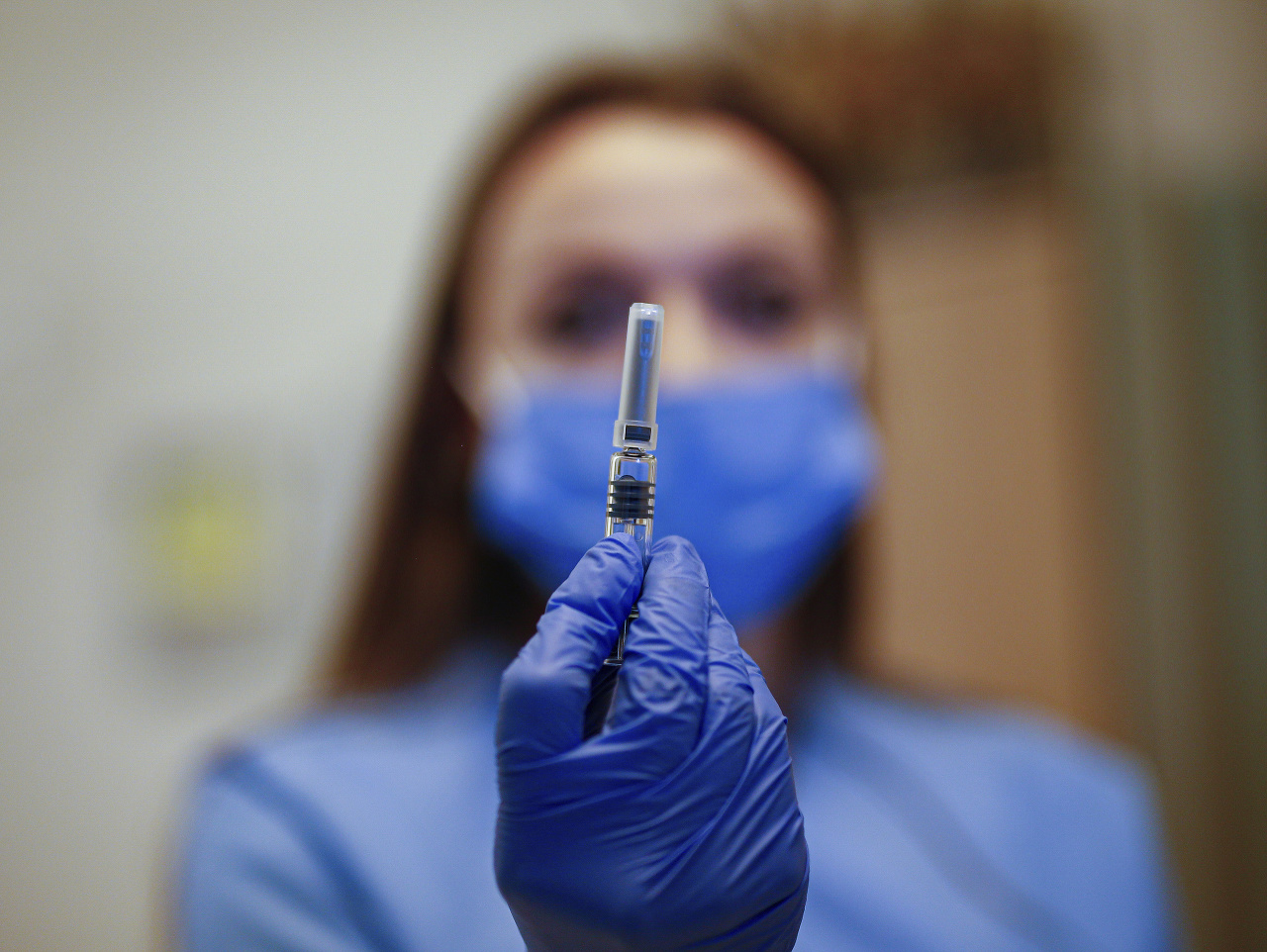 Zdravotníčka ukazuje ampulku s prvou dávkou vakcíny na ochorenie Covid-19, ktorou zaočkuje lekára urgentnej medicíny Cemova Guna