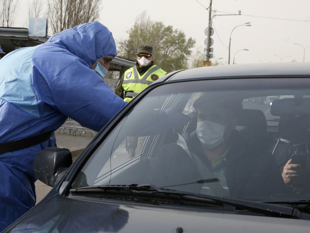 Zdravotník na Ukrajine kontroluje vodičovi teplotu
