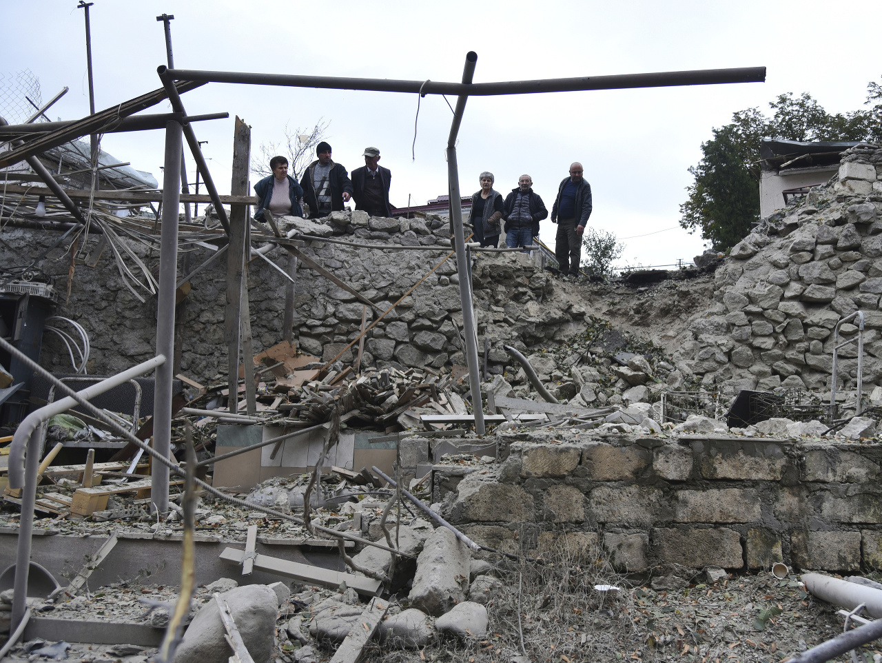 Muži sa pozerajú na škody v obytnej štvrti po ostreľovaní delostrelectvom Azerbajdžanu počas vojenského konfliktu v samozvanej republike Náhorný Karabach.