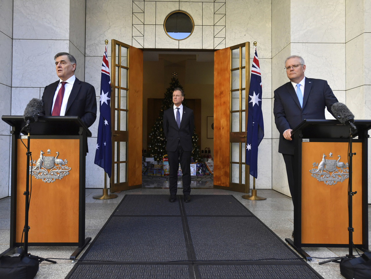 Austrálsky premiér Scott Morrison (vpravo), Brendan Murphy (vľavo) a austrálsky minister zdravotníctva Greg Hunt
